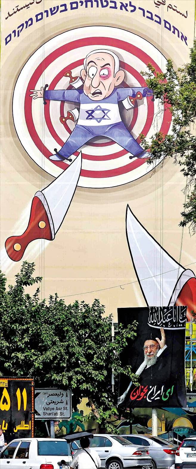 < 표적 된 네타냐후 > 베냐민 네타냐후 총리를 조롱하는 풍자화가 지난 13일 이란 수도 테헤란 광장의 한 건물 외벽에 걸렸다. 풍자화에는 ‘너는 어디에서도 안전하지 않다’라는 문구가 쓰여 있다. /AFP연합뉴스