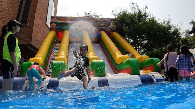 서울 노원구 호산나교회 초등부 어린이가 지난해 7월 교회 앞마당에 설치된 수영장 워터슬라이드를 타고 내려오며 손가락으로 브이(V) 자를 그리고 있다. 호산나교회 제공