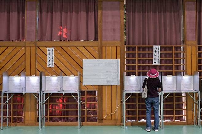 2025년 7월 20일, 일본 도쿄의 한 투표소에서 한 유권자가 참의원 선거에 참여하고 있다.(사진=AFP)