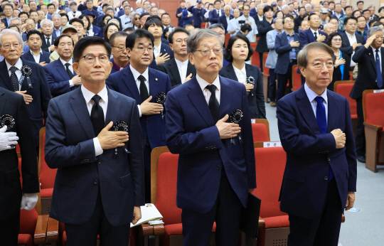 지난 19일 서울 동작구 국립현충원 현충관에서 열린 이승만 전 대통령 서거 60주기 추모식에서 정운찬 전 국무총리, 김황식 이승만건국대통령기념사업회 이사장, 김문수 상임고문이 국기에 경례하고 있다. 연합뉴스