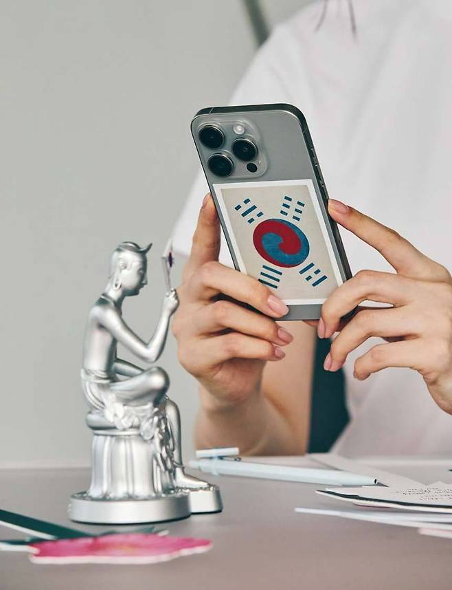 데니 태극기를 소재로 한 스티커와 데니 태극기를 들고 있는 '반가사유상 미니어처: 광복에디션'. /사진=국립중앙박물관