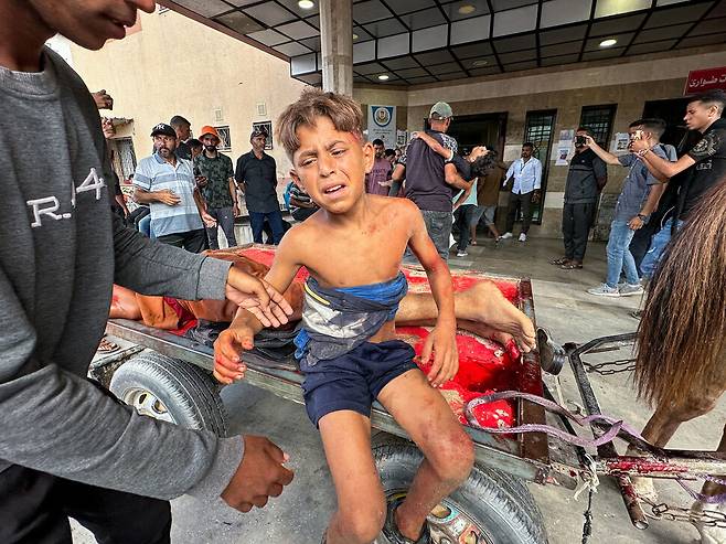 20일 가자 지구 남부 칸 유니스 식량 보급소 주변에서 일어난 이스라엘군의 총격으로 상처를 입은 아이가 수레에 실려 인근 병원에 도착했다. 로이터 연합뉴스