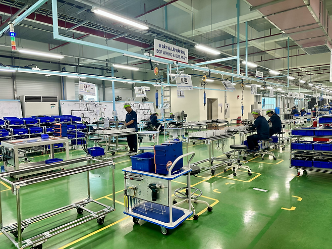 Employees work at the wiring and subassembly line for battery control panels at LS Electric’s Bac Ninh plant, east of Hanoi, Vietnam, July 14. (Byun Hye-jin/The Korea Herald)