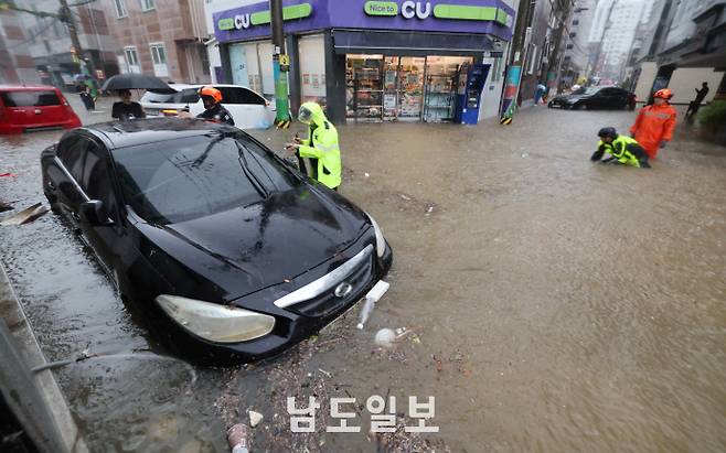 극한 호우에 물에 잠긴 도심호우경보가 발효된 17일 광주광역시 북구 용봉동 한 도로가 물에 잠겨 차량이 침수된 가운데 현장에 출동한 소방대원들이 배수작업 등 구조활동을 하고 있다. /임문철 기자 35mm@namdonews.com