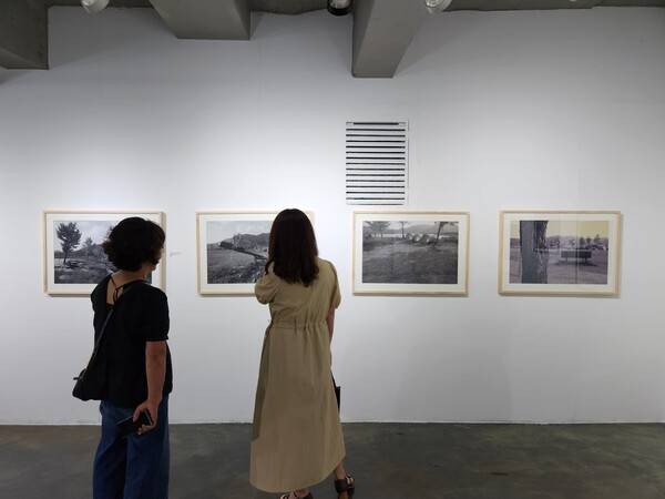 21일 창원 창동예술촌 창동갤러리에서 열린 제2회 2025경남썸머사진영상축제에서 관람객들이 작품을 감상하고 있다. /류민기 기자