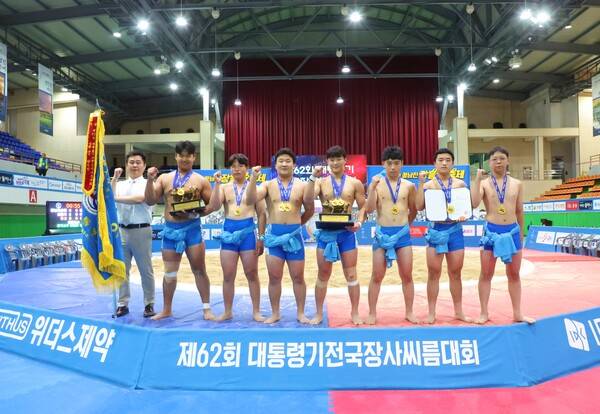 마산중학교 씨름부 선수들이 21일 전남 장흥군 장흥실내체육관에서 열린 '제62회 대통령기전국장사씨름대회' 중학부 단체전에서 우승을 차지한 뒤 심우현(왼쪽 첫번째) 감독과 함께 기념사진을 찍고 있다.