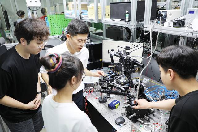 DGIST 한상윤 로봇및기계전자공학과 교수(가운데)가 학생들과 실리콘 포토닉스 연구를 하고 있다. DGIST 제공