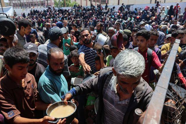 20일 가자지구 중부 누셰이라트에서 주민들이 식량을 배급받고 있다. 누셰이라트=로이터 연합뉴스
