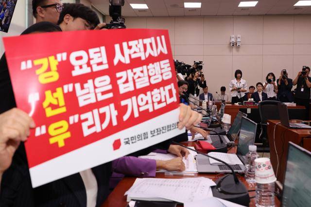14일 국회 여성가족위원회의 강선우 여성가족부 장관 후보자 인사청문회에 참석한 조은희 국민의힘 의원(얼굴 가려진 인물)이 강 후보자 사퇴를 촉구하는 피켓을 들고 있다. 연합뉴스