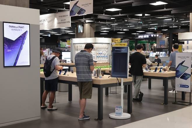 이동통신 3사가 22일부터 최신 폴더블폰 ‘갤럭시 Z 폴드7·플립7’ 사전 예약 고객을 대상으로 개통을 시작했다. 이날 서울 시내 대형마트 가전매장에서 시민들이 최신 폴더블폰 ‘갤럭시 Z 폴드7·플립7’을 살펴보고 있다. 연합뉴스