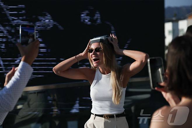 21일(현지시간) 미국 로스엔젤레스에서 열린 테슬라 다이너 앤 드라이브인 레스토랑과 슈퍼차저 개장식에서 한 참석자가 테슬라 사이버트럭 푸드 박스를 모자 처럼 쓰고 있다. ⓒ AFP=뉴스1