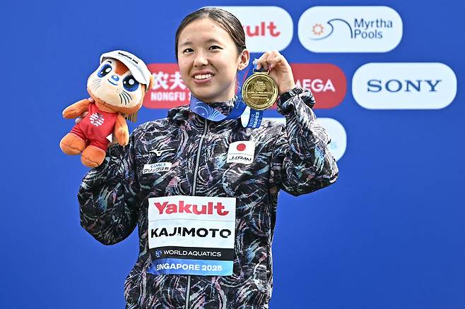 일본 여자 수영 카지모토 이치카가 지난 19일 싱가포르 센토사섬에서 열린 세계선수권 3㎞ 녹아웃 스프린트 종목 시상대에서 금메달을 들어보이고 있다./AFP 연합뉴스