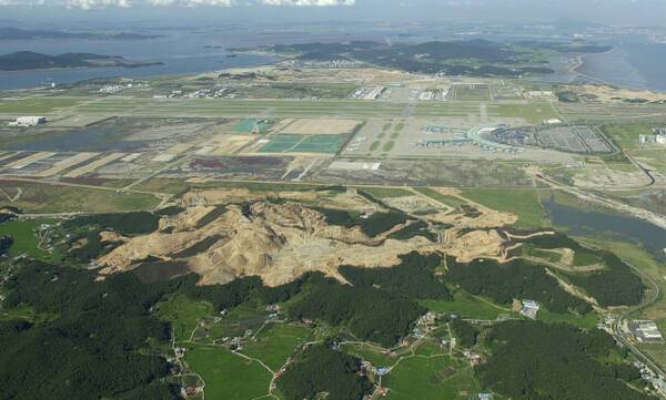지난 2004년 7월 인천공항의 항공기 운항 안전 확보를 위해 오성산을 절토하고 있는 모습. 오성산 뒷편으로 인천공항이 보인다. 인천국제공항공사 제공