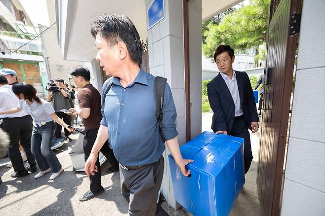 내란·외환 특별검사팀(조은석 특검)이 24일 서울 종로구에 있는 한덕수 전 국무총리 자택 압수수색을 마친 뒤 압수품을 들고 이동하고 있다. 연합뉴스