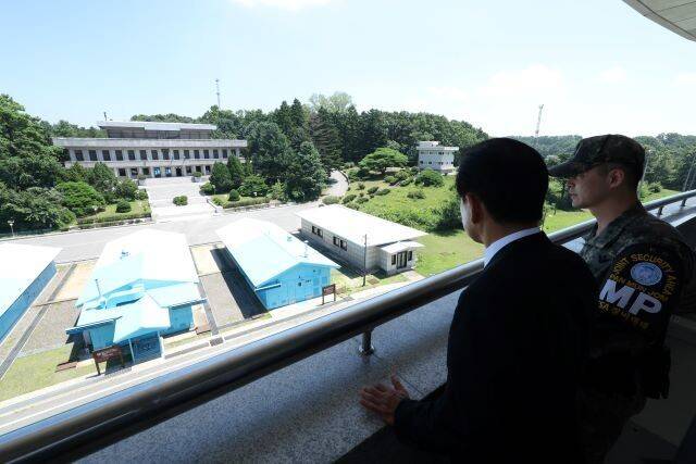 정동영 통일부 장관(오른쪽 둘째)이 25일 낮 경기도 파주시 판문점 ‘공동경비구역’(JSA) 남쪽 구역 ‘자유의 집’ 난간에서 군사분계선(MDL) 너머 북쪽의 판문각(사진 왼쪽 위 건물)을 바라보고 있다. 사진 통일부 제공