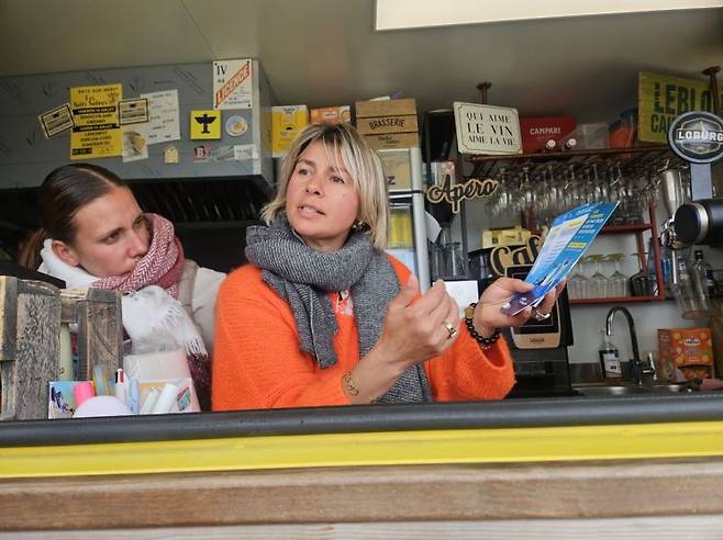 프랑스 바츠 쉬르 메르(Batz-sur-Mer)에서 5년째 카페를 운영 중인 카펠리엔(오른쪽)이 상인들에게 제공한 해상풍력 관련 일문일답 책자를 펼쳐보이고 있다. 전진영 기자.