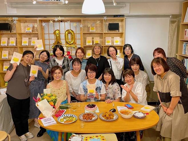 2025년 7월 7일 책거리 10주년을 맞아 책방에 모인 김승복 대표(맨 앞줄 가운데)와 역대 점장들. 각자 손에 김 대표의 책 '결국 다 좋아서 하는 거잖아요'를 들고 있다./김승복 대표 제공