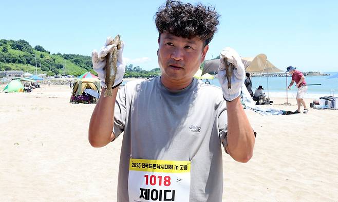26일 전남 고흥군 영남면 남열해돋이 해수욕장 일원에서 열린 ‘2025 고흥 드론 서머비치 페스타’ 전국드론낚시대회에서 '제이디'팀이 잡은 고기를 들어 보이고 있다. 고흥=이제원 선임기자