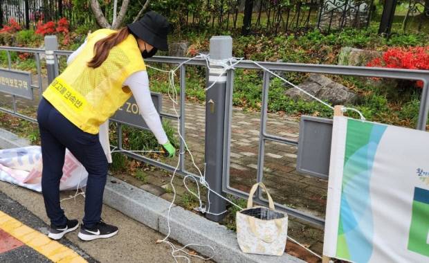 광주시청 불법 광고물 단속반원이 도로 변에 설치된 불법 현수막을 떼어내고 있다.
