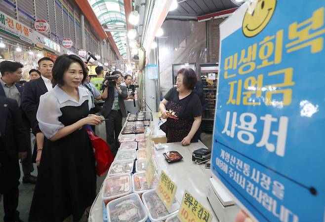 김혜경 여사가 25일 민생회복 소비쿠폰 이용을 위해 인천 계양산전통시장을 방문해 한 매장에서 판매되는 반찬을 살피고 있다. 연합뉴스