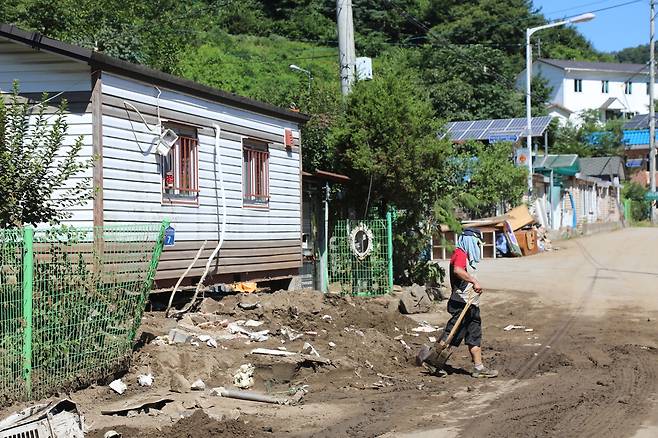 27일 폭우 피해를 입은 경기 가평군 조종면 대보2리에서 한 주민이 삽을 들고 이동하고 있다. 가평=연합뉴스