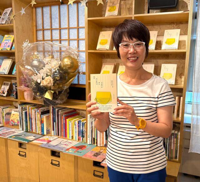 일본 도쿄에서 한국어 전문 책방 '책거리'를 운영하는 김승복 대표가 자신의 책 '결국 다 좋아서 하는 거잖아요'를 들고 미소 짓고 있다. 김승복 대표 제공
