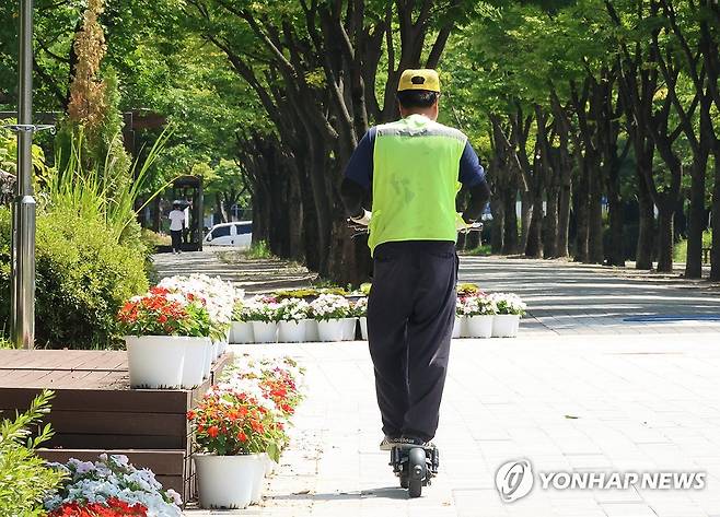 폭염경보 내린 대전 한 공원 (대전=연합뉴스) 강수환 기자 = 폭염경보가 내려진 28일 대전 서구 둔산동 한 공원에서 노상주차장을 관리하는 근로자가 개인형 이동장치를 타고 일하고 있다. 2025.7.28 swan@yna.co.kr