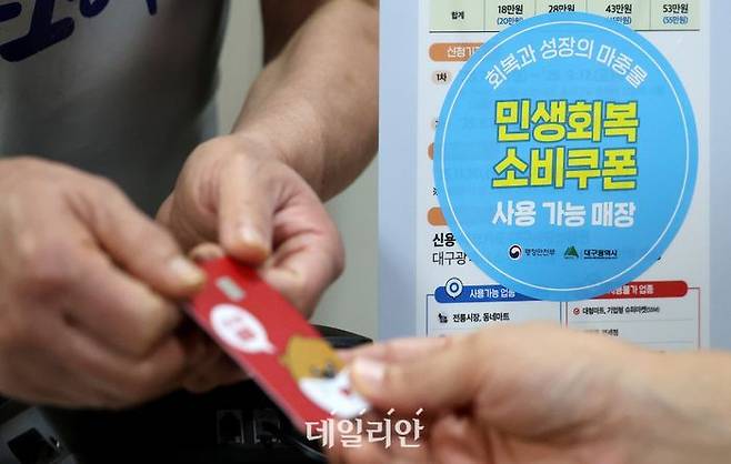 민생회복 소비쿠폰 신청 이틀재인 지난 22일 대구 중구 한 음식점에서 식사를 마친 시민이 소비쿠폰이 입금된 선불카드로 결제하고 있다.ⓒ뉴시스