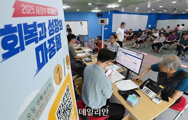 정부의 민생회복 소비쿠폰 1차 신청 첫날인 지난 21일 경기 수원시 인계동 행정복지센터에서 시민들이 지원금을 신청하고 있다.ⓒ뉴시스