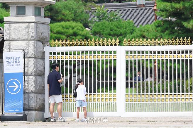 청와대 앞에서 한 어린이와 아빠가 내부를 들여다 보고 있다.