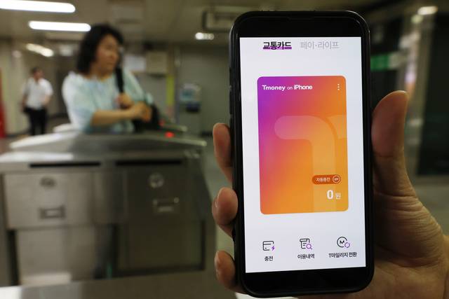 애플페이에 티머니 서비스가 적용된 이달 22일 서울 시내 한 지하철역에서 한 소비자가 아이폰의 교통카드 기능을 시연하고 있다. 연합뉴스