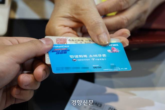 민생회복 소비쿠폰 1차 신청이 시작된 지난 21일 서울 동작구 대방동주민센터에서 한 주민이 선불카드를 발급받고 있다. 성동훈 기자