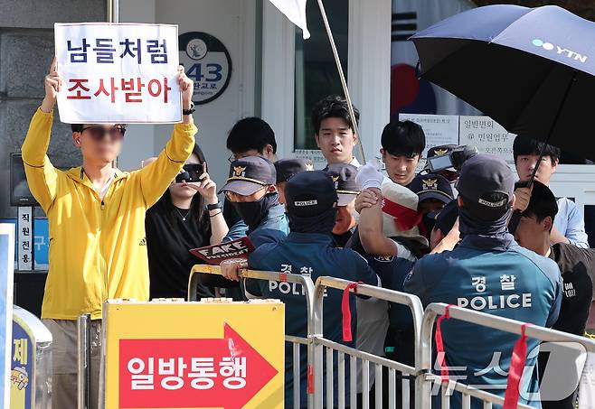 김건희 여사의 각종 의혹을 수사하는 김건희 특검팀(특별검사 민중기)이 윤석열 전 대통령에 대한 체포영장 집행에 나선 1일 오전 경기도 의왕 서울구치소에서 윤 전 대통령 지지자가 '남들처럼 조사받아' 라는 피켓을 든 한 시민에게 달려가자 경찰이 저지하고 있다. 2025.8.1/뉴스1 ⓒ News1 김성진 기자