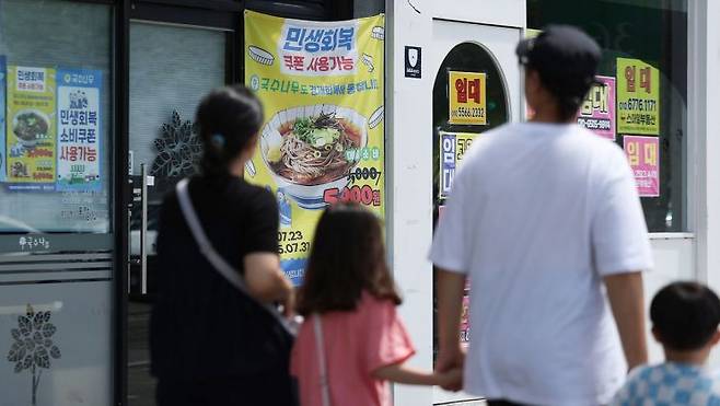 지난달 27일 경북 경산시 한 상가에 민생회복 쿠폰 사용처라는 안내 현수막이 붙어 있다. 연합뉴스