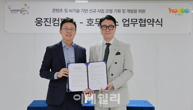 서종윤 웅진컴퍼스 대표이사(오른쪽)와 김민우 호두랩스 대표(왼쪽)가 업무협약식에서 기념사진을 촬영을 하고 있다. (사진=웅진컴퍼스)