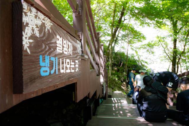 얼음골 결빙지 냉기 나오는 곳 앞에 피서객들이 옹기종기 앉아 있다.