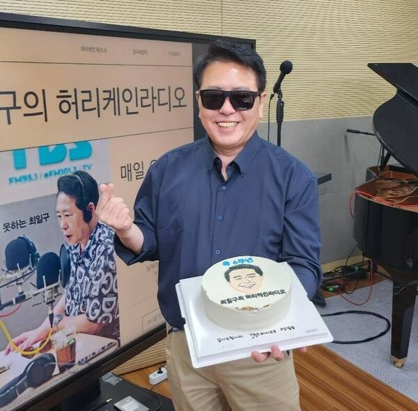 ▲최일구 TBS 라디오 최일구의 허리케인 라디오 진행자가 2023년 11월21일 6주년 기념식에 케�揚� 들고 사진촬영을 하고 있다. 사진=TBS 라디오 인스타그램