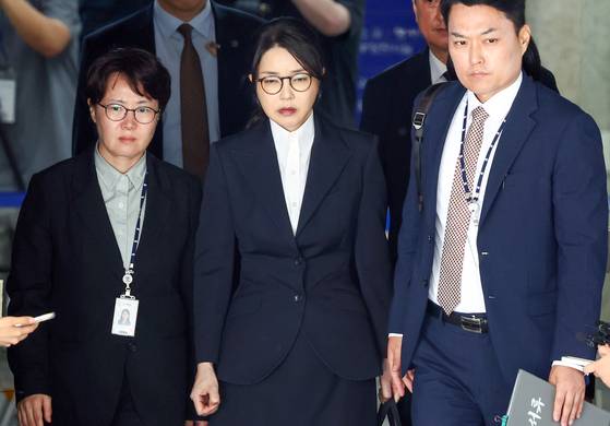 김건희 여사(가운데)가 12일 서울중앙지법에서 열린 영장실질심사를 마치고 나오고 있다. 김 여사는 이날 밤늦게 구속됐다. 사진공동취재단