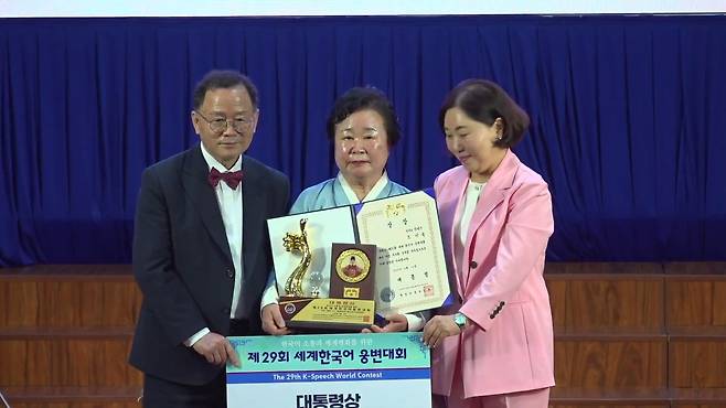 세계한국어웅변대회 베트남 호찌민서 열려 (호찌민=연합뉴스) 14일(현지시간) 베트남 호찌민 호찌민국립대 강당에서 한국인과 세계 각국의 외국인·해외동포들이 한국어 웅변 실력을 선보이는 제29회 세계한국어웅변대회가 열렸다. 'K-푸드'를 주제로 연설한 조인숙씨가 대통령상을 받는 모습. 2025.08.14