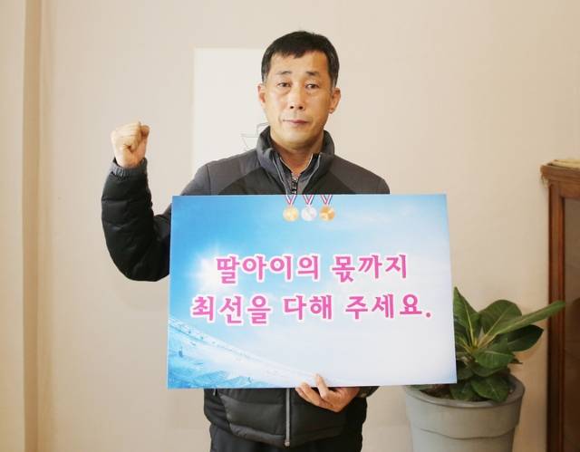 폭행과 가혹행위로 스스로 생을 마감한 트라이애슬론(철인3종) 국가대표 출신 고(故) 최숙현(당시 22세) 선수의 아버지 최영희 씨가 지난 2022년 베이징 동계올림픽에 출전한 한국대표팀을 응원하는 문구가 적힌 피켓을 들고 파이팅을 외치고 있다. / 뉴시스