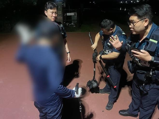 24일 오후 8시 45분쯤 파주시 공릉천 인근 공원 산책로에서 허리에 장검을 차고 다닌 A(70대)씨가 경찰에 붙잡힌 모습. 경기북부경찰청