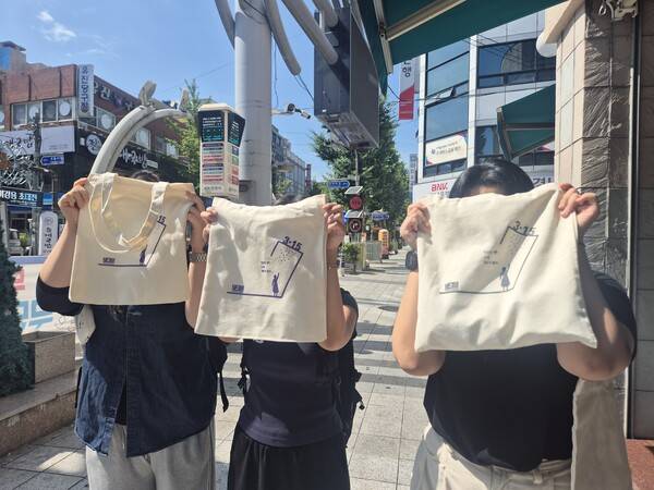 지난달 11일, 마산 3·15의거 발원지 기념관 앞에서 열린 시민 캠페인에서 학생들이 직접 제작한 3·15 기념 에코백을 시민들에게 나눠주고 있다. /마산여고