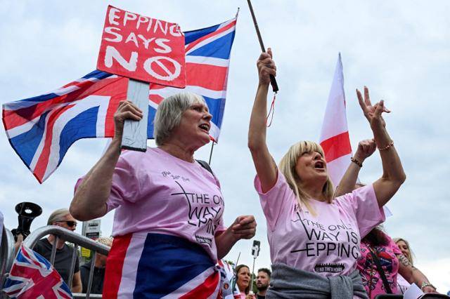 시위대가 24일 영국 에핑의 벨 호텔 밖에서 반(反)이민 시위에 참석하고 있다. 영국 정부가 망명 신청자에게 제공하는 이 호텔에는 얼마 전 14세 소녀를 성폭행한 에티오피아 출신 망명 신청자가 머물렀다. 에핑=로이터 연합뉴스