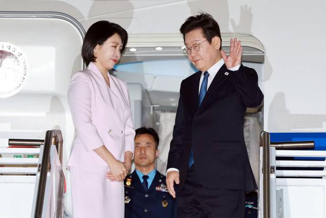 이재명 대통령과 김혜경 여사가 26일(현지시간) 미국 펜실베이니아주 필라델피아국제공항에서 미국 방문 일정을 마친 뒤 귀국하며 공군 1호기에 올라 인사하고 있다. 2025.8.27 연합뉴스