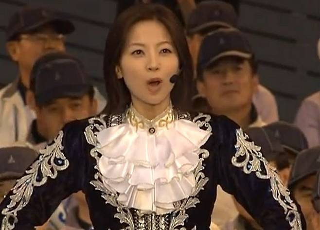 A Samsung Electronics new recruit signals the start of a mass cheering performance at the company’s 2006 retreat. (YouTube)