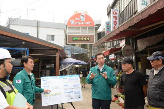 진주 자유시장 아케이드 공사 현장을 방문한 강민국 국회의원(가운데)이 진주시의회 오경훈 경제복지위원장(왼쪽)으로부터 자유시장 경관개선 사업 설명을 들은 후 상인들과 이야기를 나누고 있다.