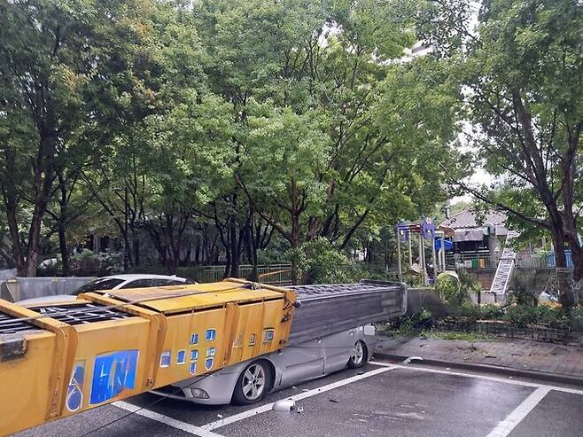 1일 오전 경기 성남시 분당구 정자동 한 아파트단지에서 이사용 사다리차가 옆으로 넘어져 주차된 차량을 파손하고, 어린이놀이터를 지나 인근 상가 건불까지 파손했다. 경기도소방재난본부 제공