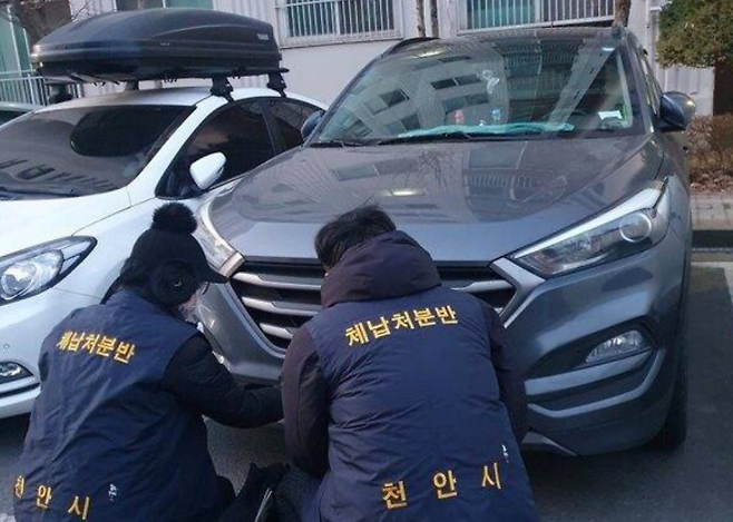 충남 천안시 관계자들이 체납 차량의 번호판을 영치하고 있다. 천안시 제공