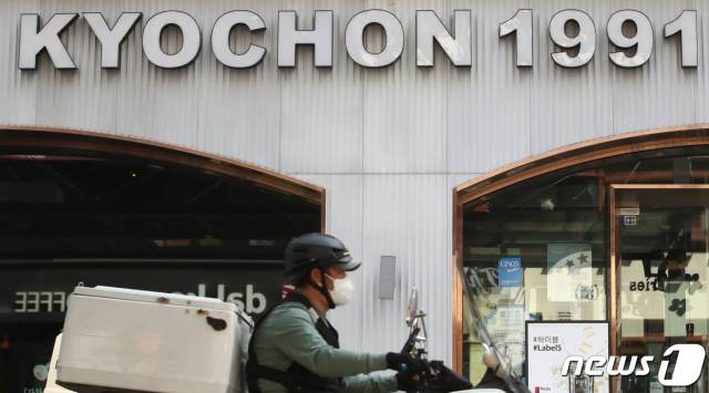 한 배달라이더가 교촌치킨 매장 앞을 지나가고 있다. 뉴스1