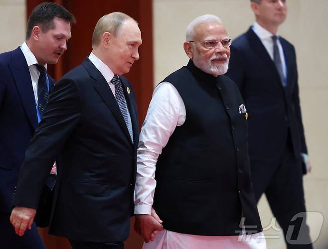 블라디미르 푸틴 러시아 대통령(왼쪽)과 나렌드라 모디 인도 총리가 1일 중국 톈진에서 열린 상하이협력기구(SCO) 정상회의에서 손을 잡고 대화하며 이동하고 있다. 2025.09.01 ⓒ 로이터=뉴스1 ⓒ News1 이지예 객원기자